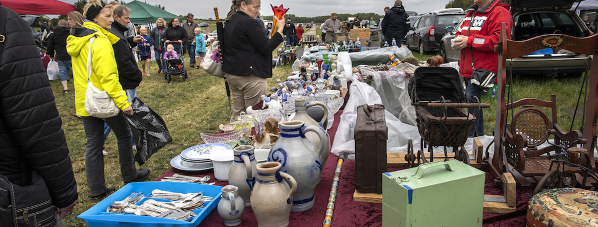 Ein Flohmarktstand voller Keramikkrüge und anderer Kuriositäten