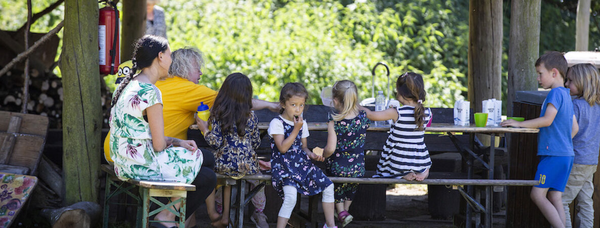 Kinder genießen eine kleine Mahlzeit im Schatten