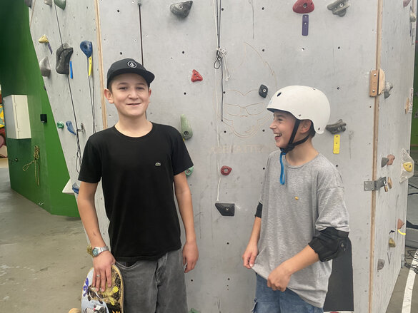 Zwei junge Skater vor eine Boulderwand