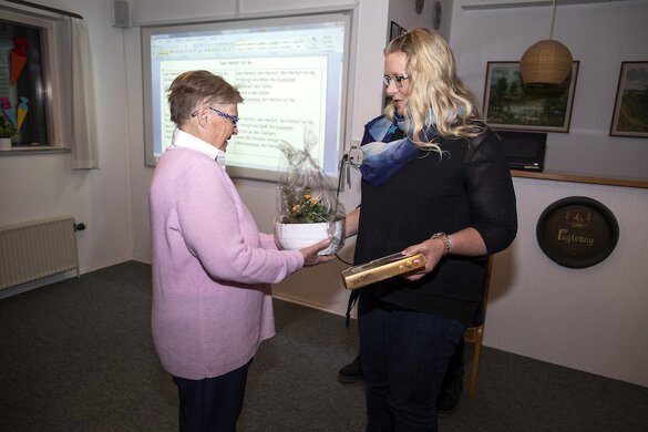 Maja Nielsen wird im Oktober 2018 anlässlich ihres fünfjährigen Jubiläums als „Lese-Oma&quot;  von der Rothenkruger Schulleiterin Carina Heymann mit einer Blume und einer Schachtel Pralinen beschenkt.de