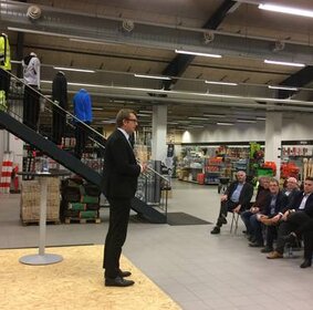 Beschäftigungsminister Troels Lund Poulsen redet im Apenrader Bygma-Baumarkt vor Vertretern von Politik und Wirtschaft.