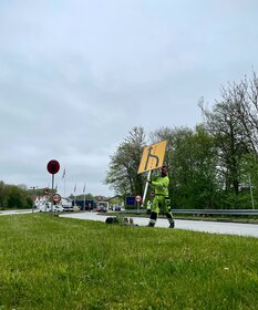 Ein Mann stellt neue Schilder an der deutsch-dänischen Grenze auf