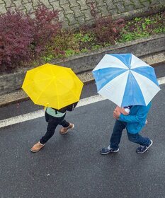 Zwei Personen mit Regenschirm