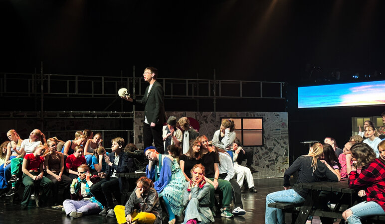 Schülerinnen und Schüler performen auf der Bühne