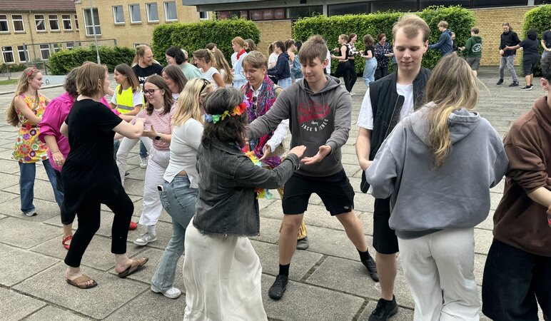Schüler- und Lehrerschaft tanzt auf dem Hof